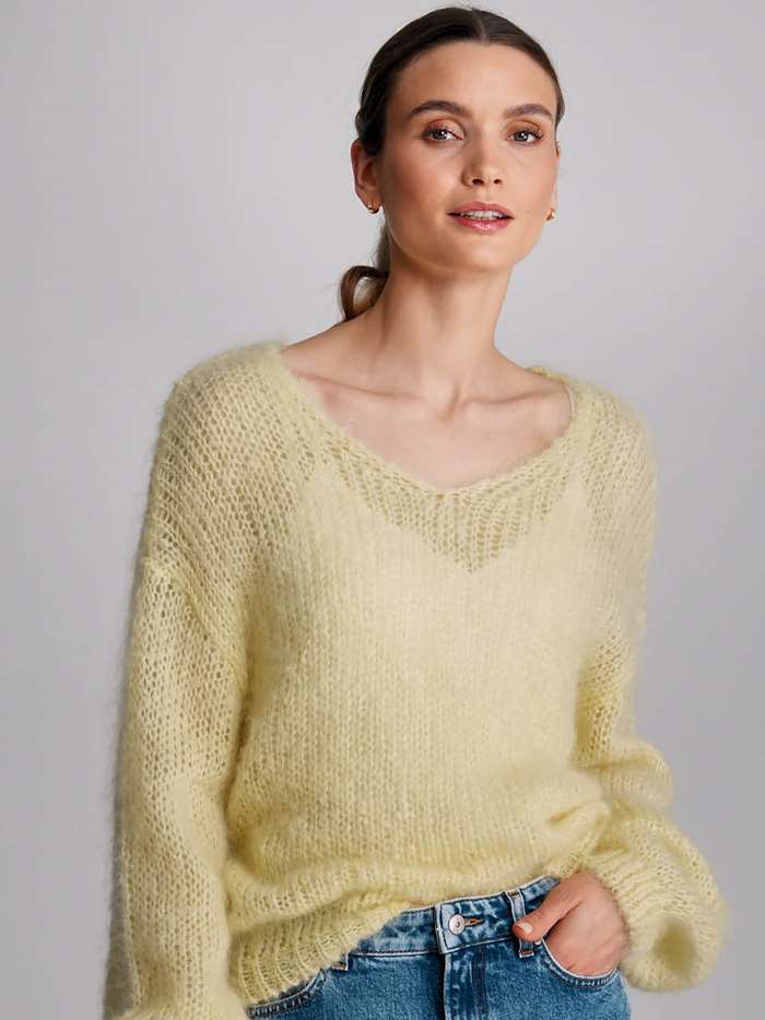 Dame i gul strikket genser